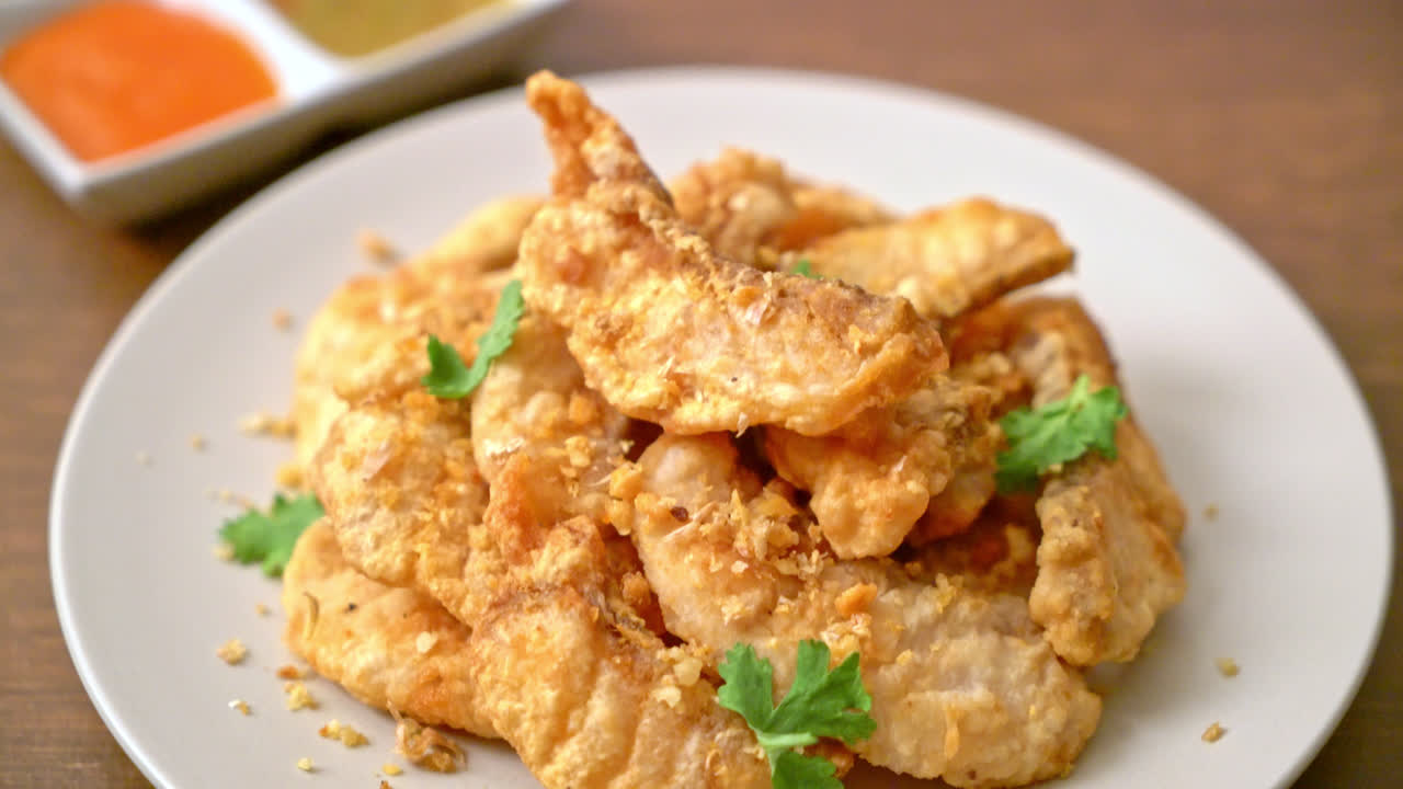 접시에 마늘과 튀긴 생선