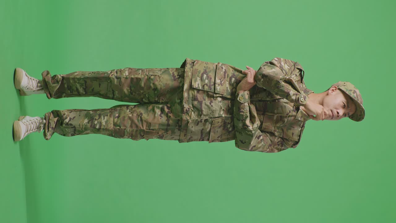 Full Body Of Asian Man Soldier Thinking And Looking Around Then Raising His Index Finger While Standing In The Green Screen Background Studio