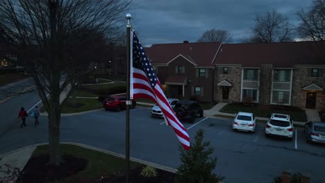 american flag waving in front of townhomes in usa suburb