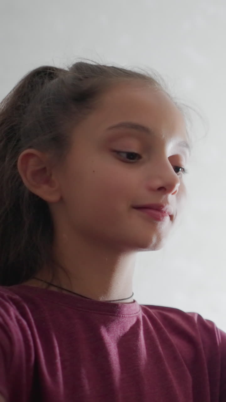Niño escribiendo con una sonrisa cálida mientras su hermana, con una blusa granate, le da un suave golpe en la cabeza en tono de broma y continúa con su actividad mientras ambos comparten un momento alegre en un ambiente hogareño y acogedor, mostrando afecto mutuo.