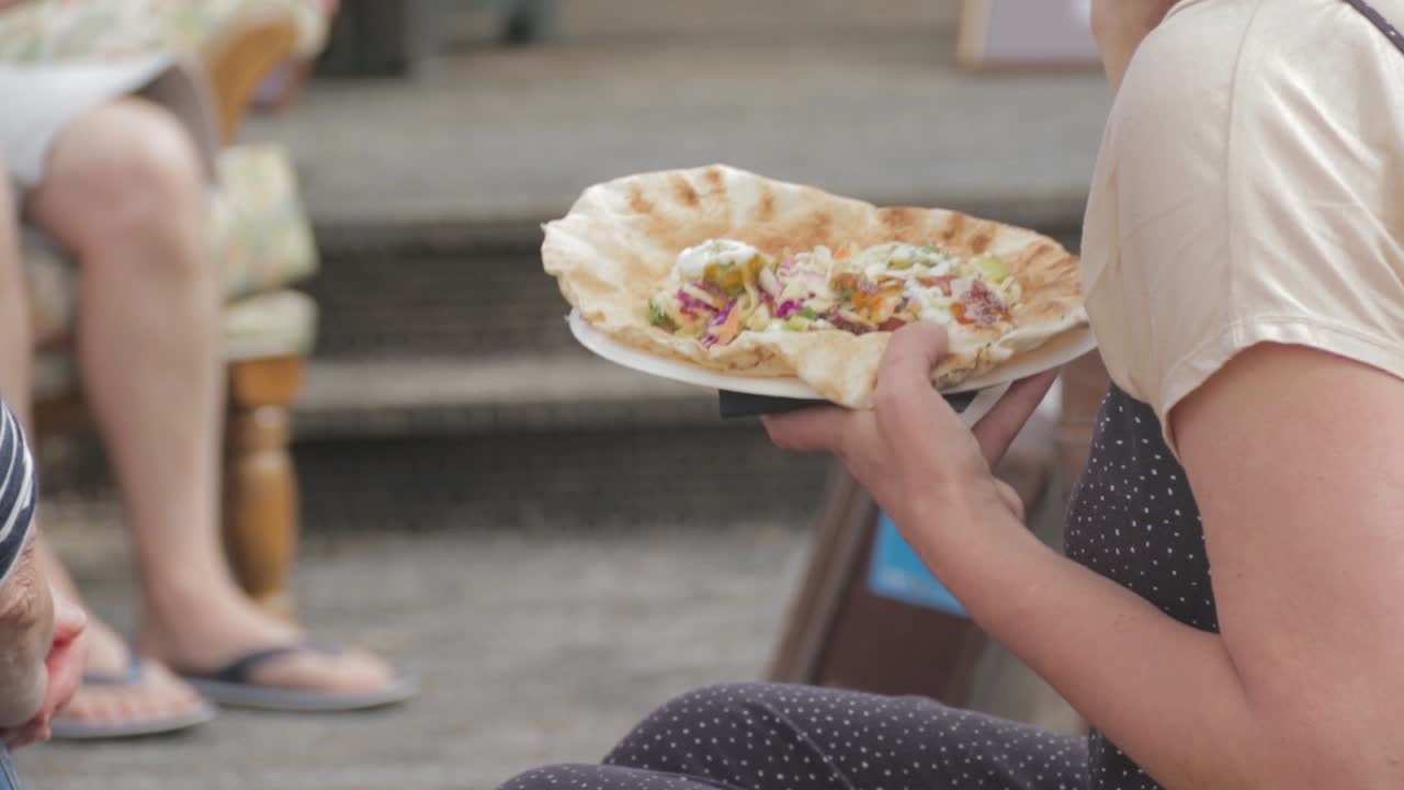 Woman eating and enjoying Tasty Flatbread Outside