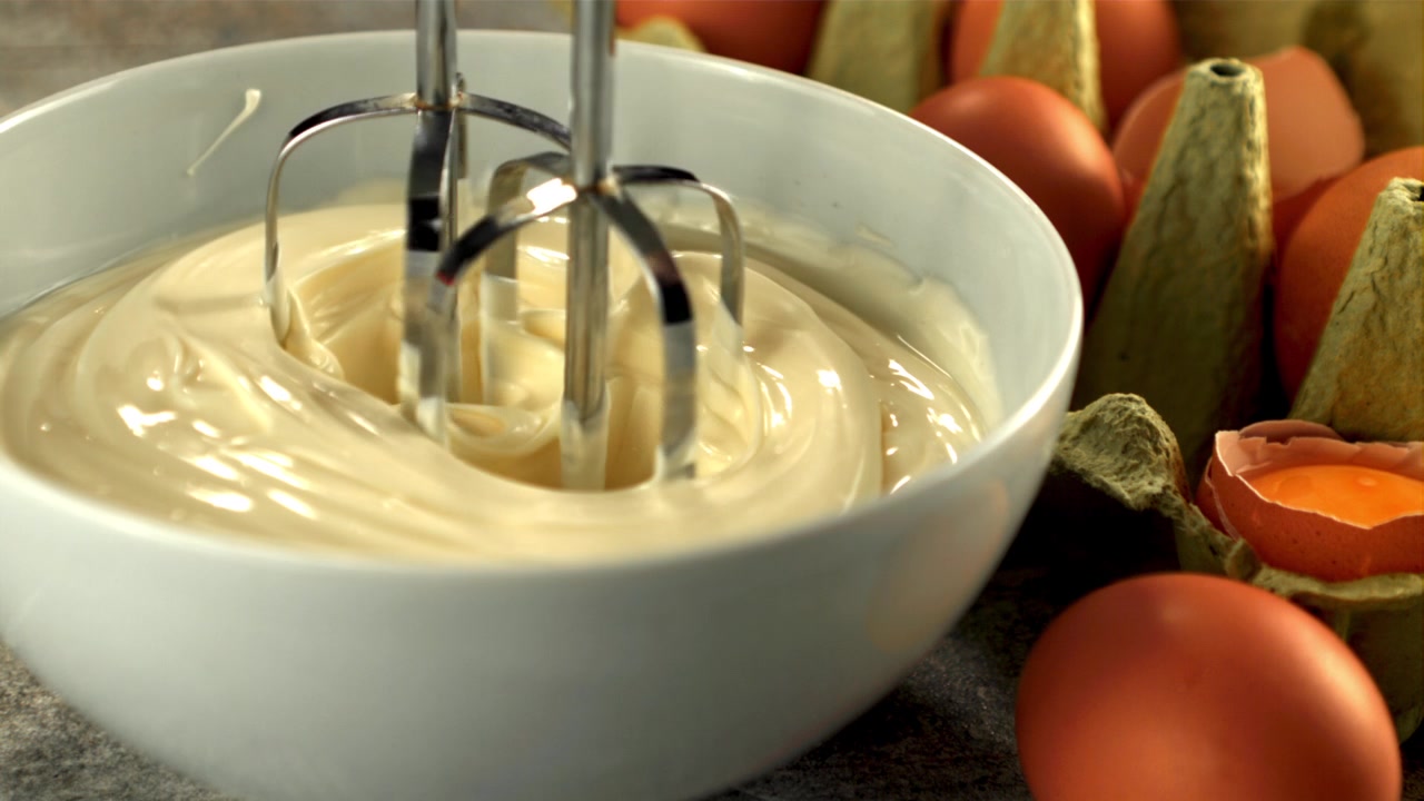 Electric Mixer Whisking Creamy Mayonnaise in a Bowl