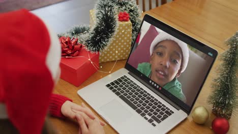 mujer caucásica en videollamada con un niño afroamericano en tiempo de navidad