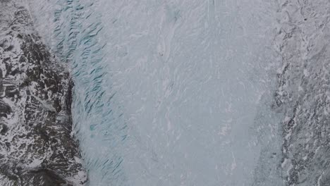 aerial top view over ice formations in virkisjokull glacier covered in snow, iceland