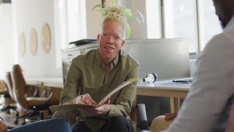 Happy-diverse-business-people-discussing-with-documents-in-creative-office