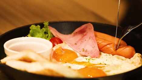 huevos fritos, jamón y pan en un plato