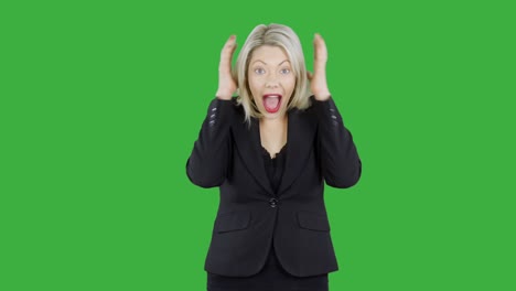 attractive blonde woman in front of chroma key green screen is happy surprised and shocked