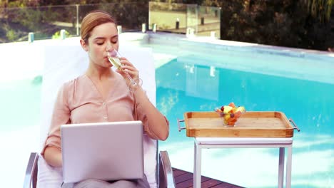 Schöne-Frau,-Die-Champagner-Trinkt-Und-Einen-Laptop-Benutzt