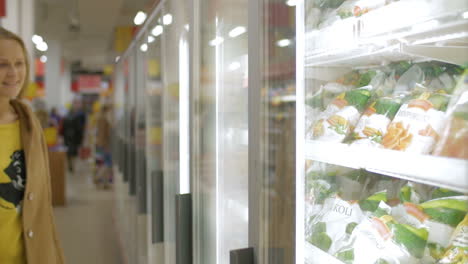 Woman-taking-frozen-product-in-the-shop-fridge