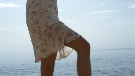 Woman-jumping-sea-waves-on-sunlight-close-up.-Girl-legs-splashing-ocean-water.