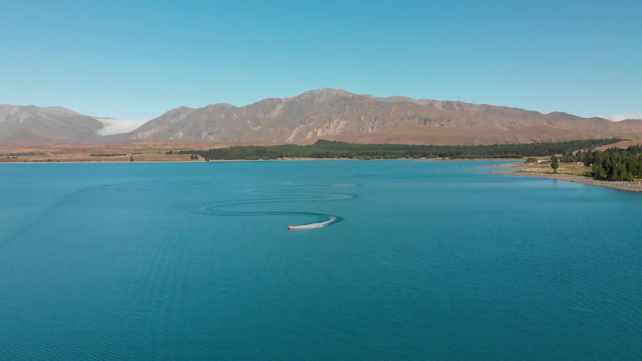 cámara lenta - jet ski en hermosas aguas azul turquesa - lago tekapo, nueva zelanda - antena