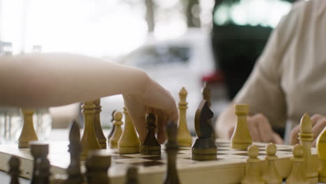 close up of unrecognizable father and son playing chess outdoors