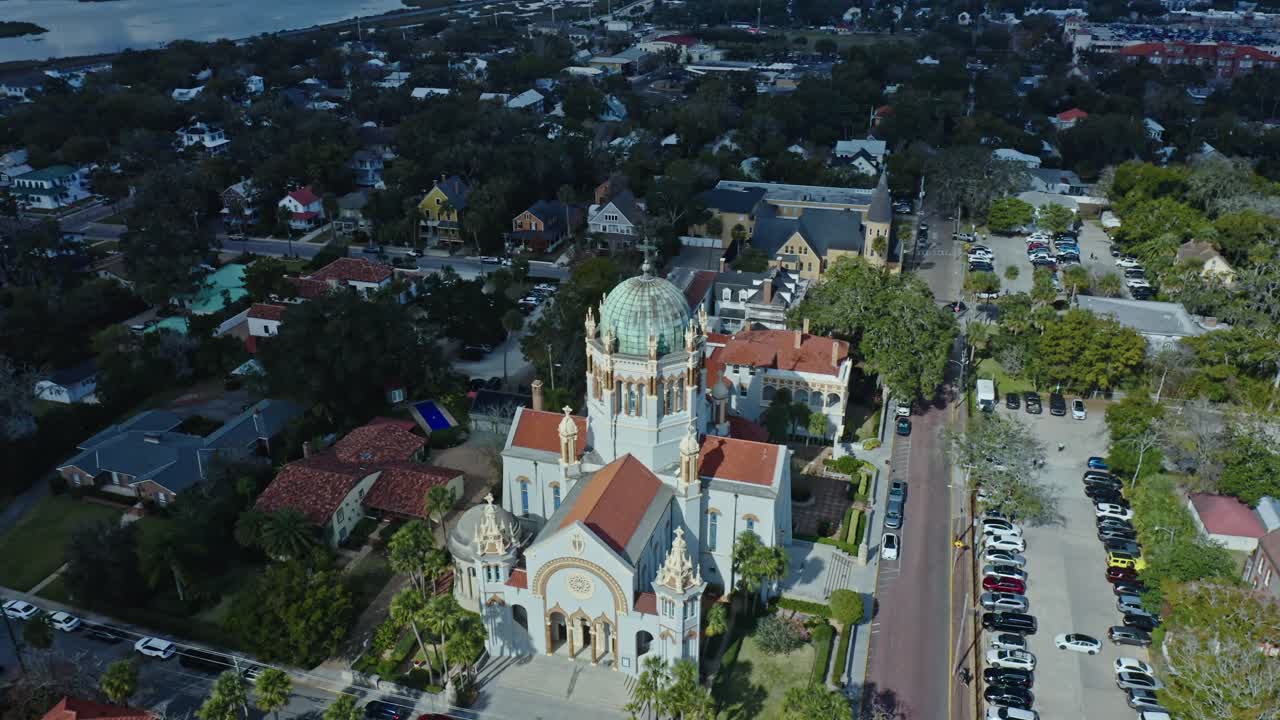 A Igreja Ponce de Leon, um edifício histórico com características arquitetônicas distintas, é mostrada de cima ao longo de uma rua movimentada com carros estacionados em Saint Augustine, Flórida