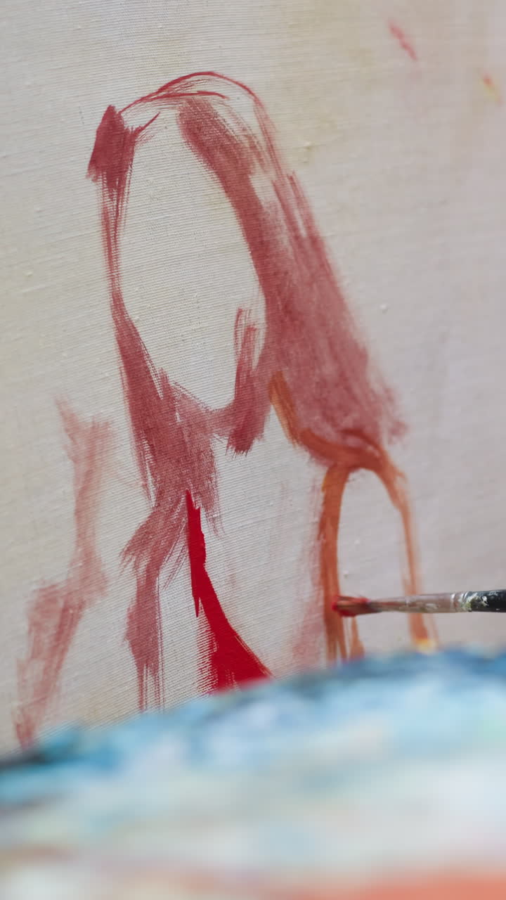 아티스트는 스튜디오 클로즈업에서 은 드레스를 입은 여자를 그립니다. 남자는 캔버스에 아크릴 페인트 스트로크를 만들고 미술 워크을 만니다. 가게에서 그림을 그리는 마스터