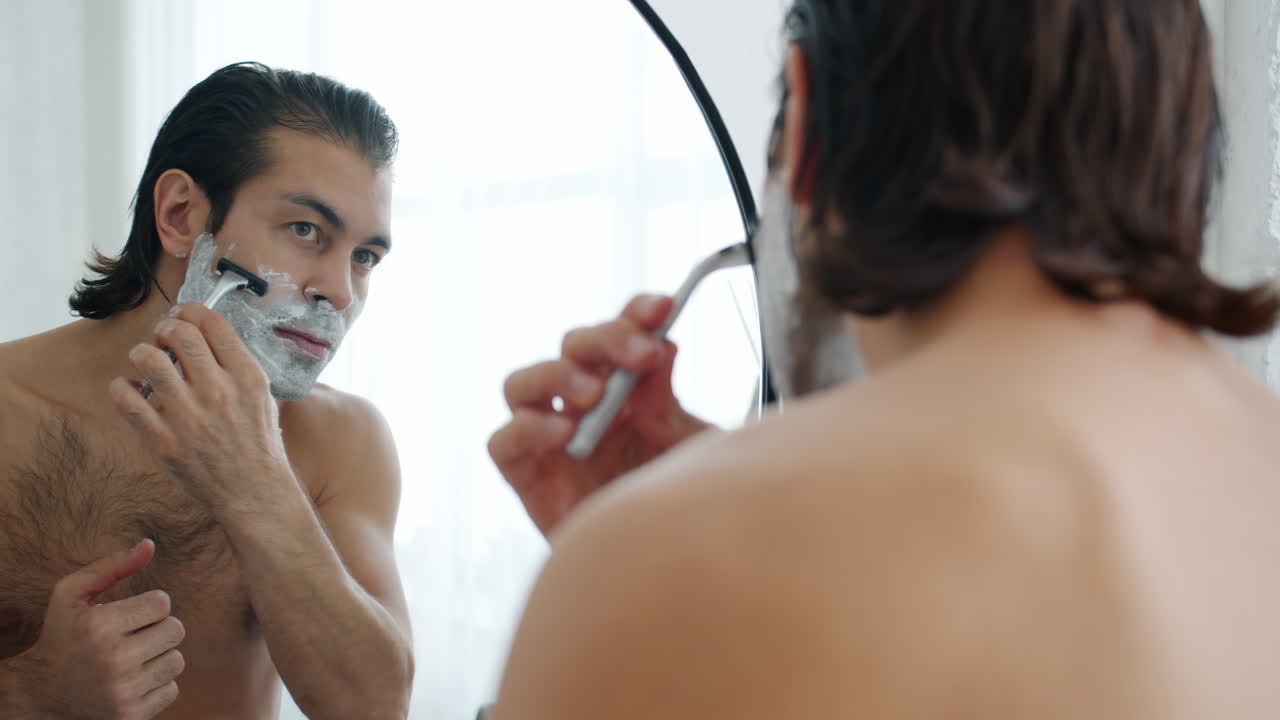 Man Shaving in Front of Mirror