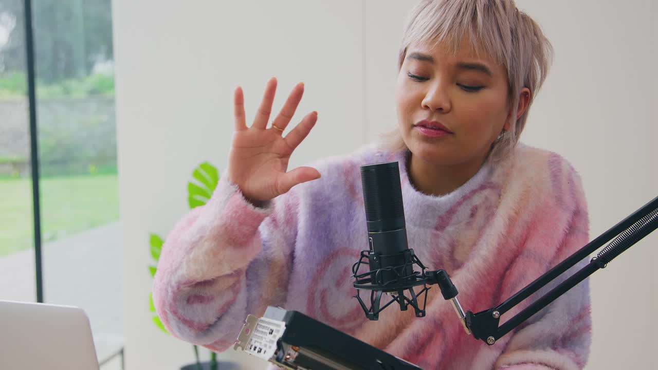 vlogger femenina con computadora portátil y micrófono transmisión en vivo en línea revisión de productos electrónicos a la cámara