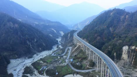 aerial view of a highway winding through mountains in china