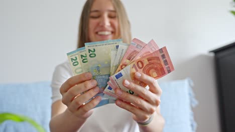 young cheerful woman counting paper money in her hands, static