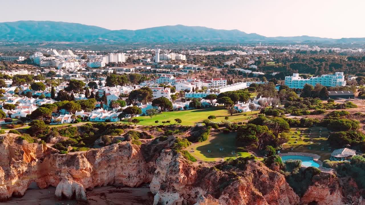 Kystudsigt over en by i Portugal med bygninger og et naturligt landskab