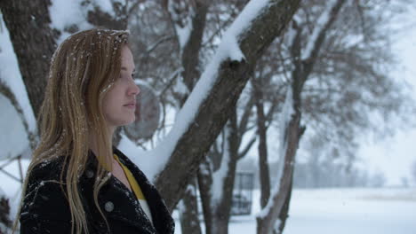 mujer feliz afuera en cámara lenta nieve de invierno como copos de nieve caen en cámara lenta cinematográfica