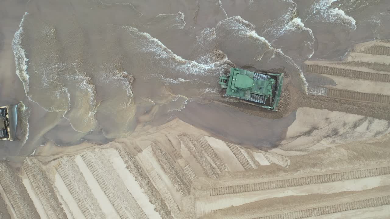 해안 건설 프로젝트에서 작업하는 토지 이동 장비의 공중 사진.