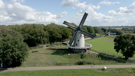 flying away from rotating windmill, revealing beautiful green meadows