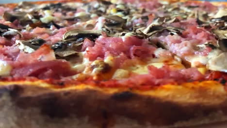 spinning pizza with burnt crust in slow motion close up