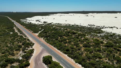 largo camino recto rodeado de tierras bajas secas y arenosas
