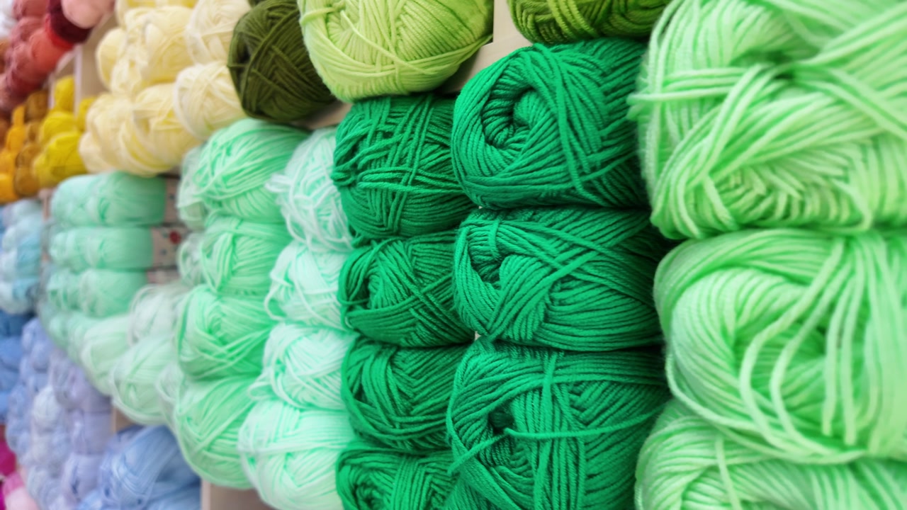 Close-up of Colorful Yarn Balls Arranged by Color on Shelves