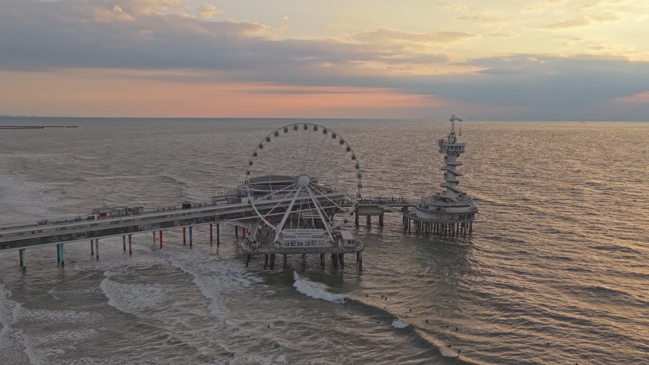オランダ、スヘフェニンゲン桟橋の夕焼け空撮、観覧車と輝く海