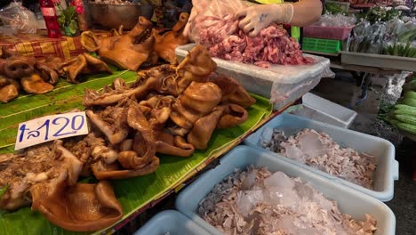 vendor arranging various meats at market stall