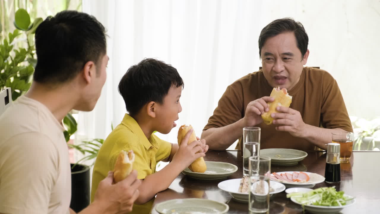 hombres asiáticos y un niño sentados en la mesa