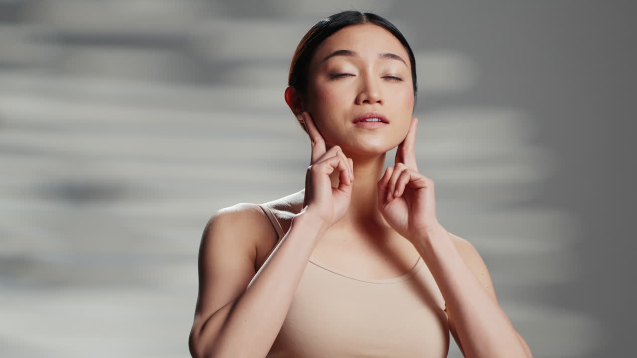 Asian woman practicing facial massage