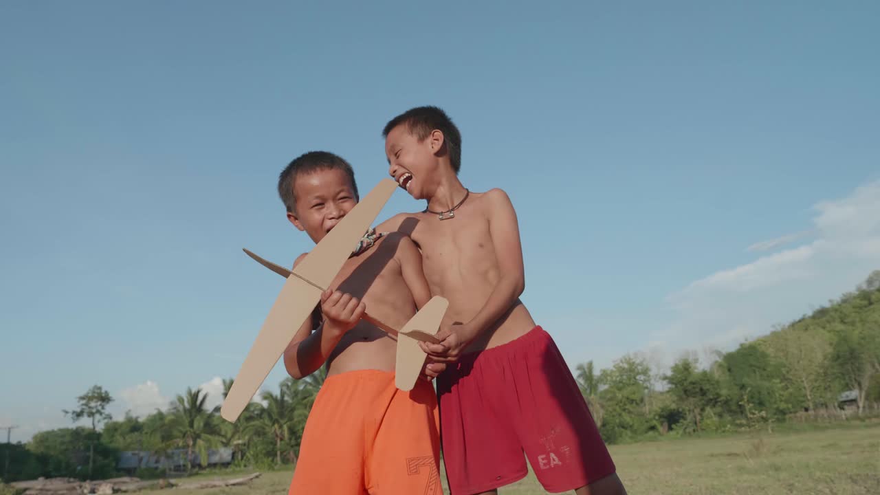 Two Boys Playing with a Homemade Cardboard Airplane