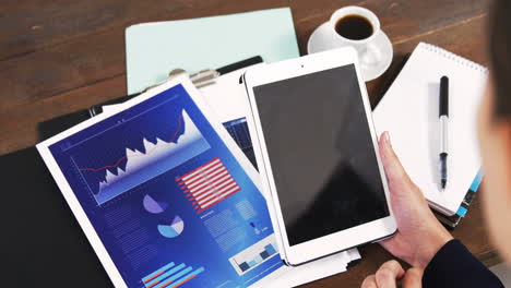 businesswoman using digital tablet with graph document and diary