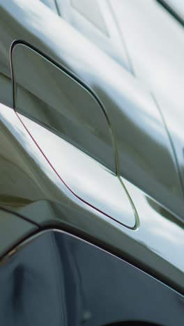 vertical video close up of driver disconnecting ev vehicle from charging dock, low angle shot