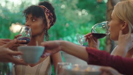 two-women-making-toast-drinking-wine-celebrating-at-dinner-party-greeting-friends-enjoying-reunion-gathering-sitting-at-table-outdoors-4k-footage