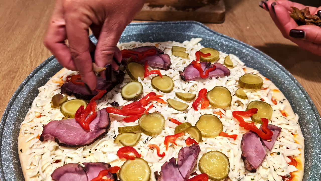 Layering fresh toppings on a homemade pizza, ready for a cozy home-cooked meal