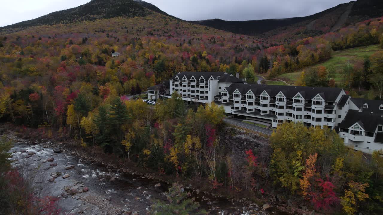 Flying over rocky river near Loon Mountain resort during fall scenery
