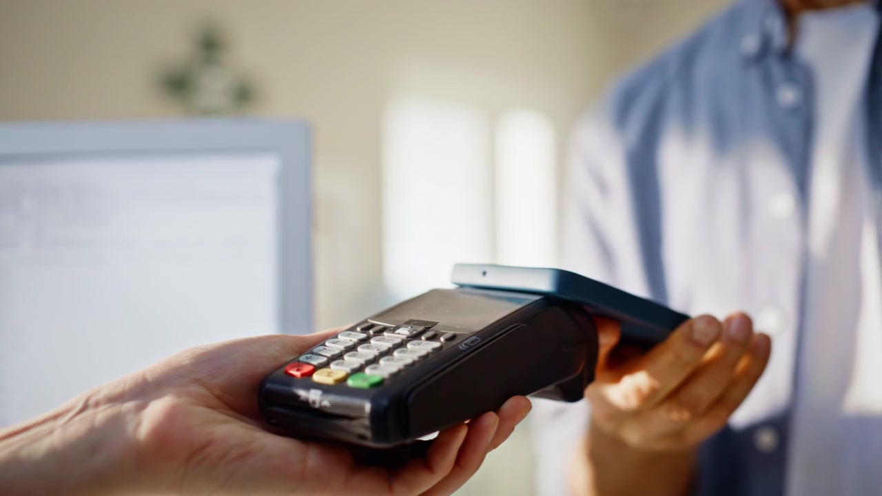Seller hands entering payment details giving terminal machine to client closeup