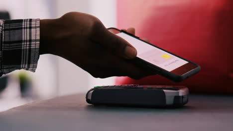 shopper putting phone on pos terminal