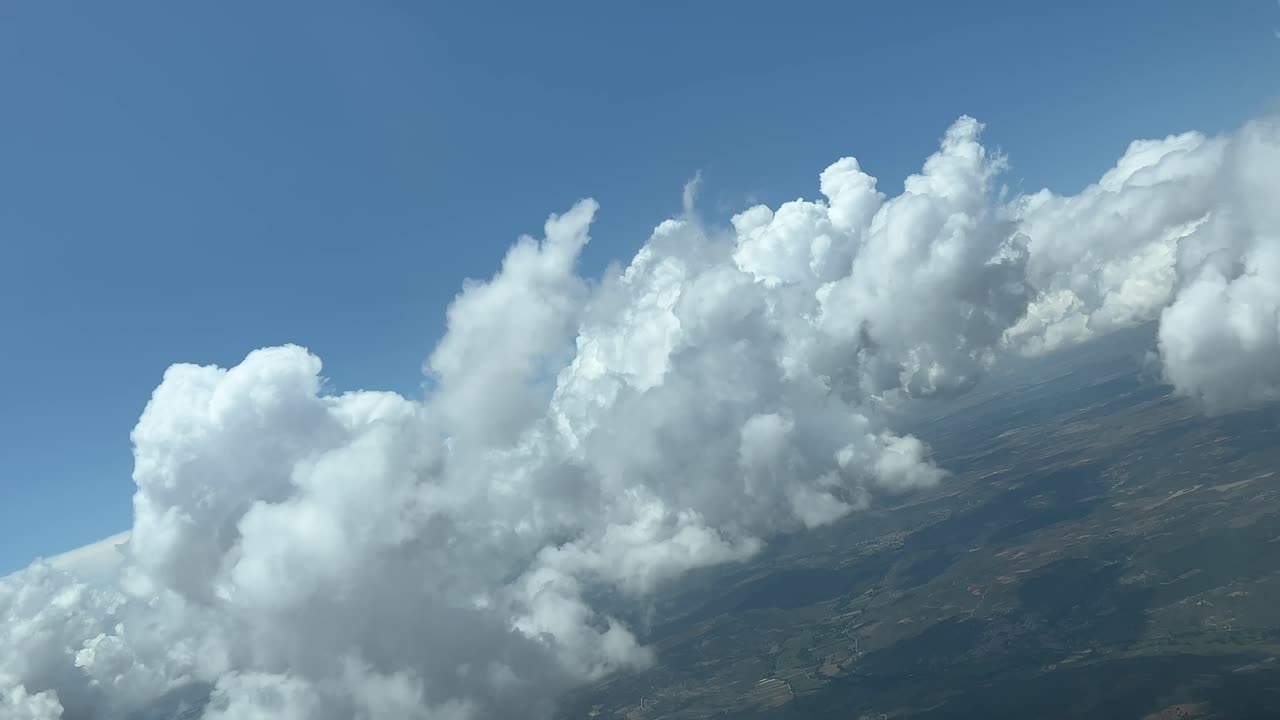 Unique pilot&rsquo;s perspective while flying trough a sky with some fluffy tiny clouds during a right turn
