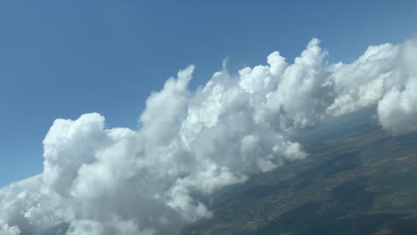 perspectiva única del piloto mientras vuela a través de un cielo con algunas nubes pequeñas y esponjosas durante un giro a la derecha