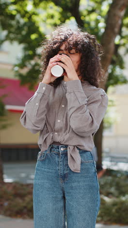 Una-Joven-Feliz-Disfrutando-Bebiendo-Café-Por-La-Mañana,-Una-Bebida-Caliente-Relajándose-Tomando-Un-Descanso-En-Las-Calles-De-La-Ciudad