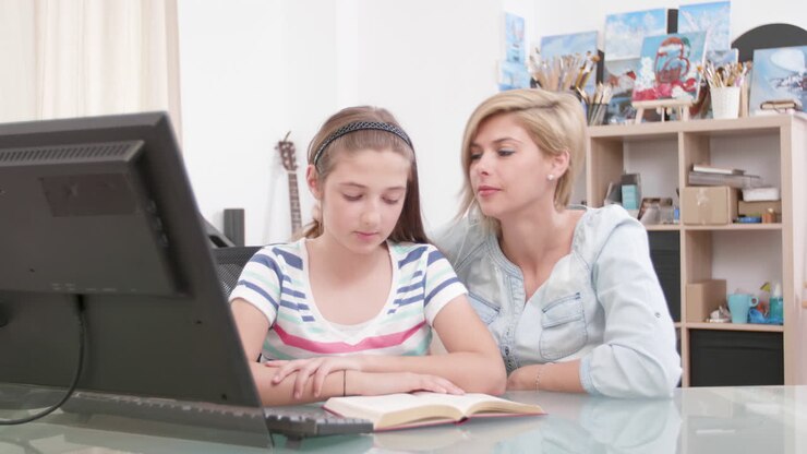 Mother helping daughter with computer work