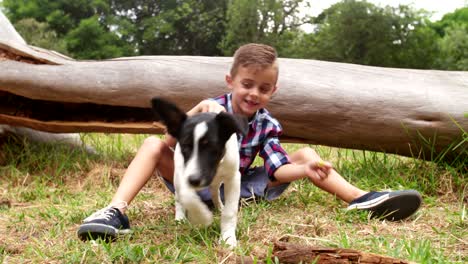 happy boy and his puppy dog frolicking around in grass