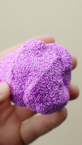 hands knead violet floam-slime in close-up, a fun asmr sensory toy loved by kids