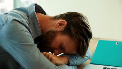 un dirigente maschio che si riposa alla sua scrivania in ufficio