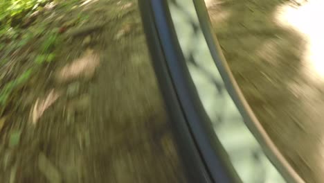 low angle view of a bike tire moving over a dirt path.