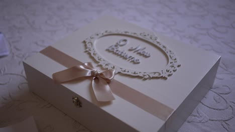 decorative baptism keepsake box with a pink ribbon and ornate lettering on a lace covered surface, perfect for storing special mementos